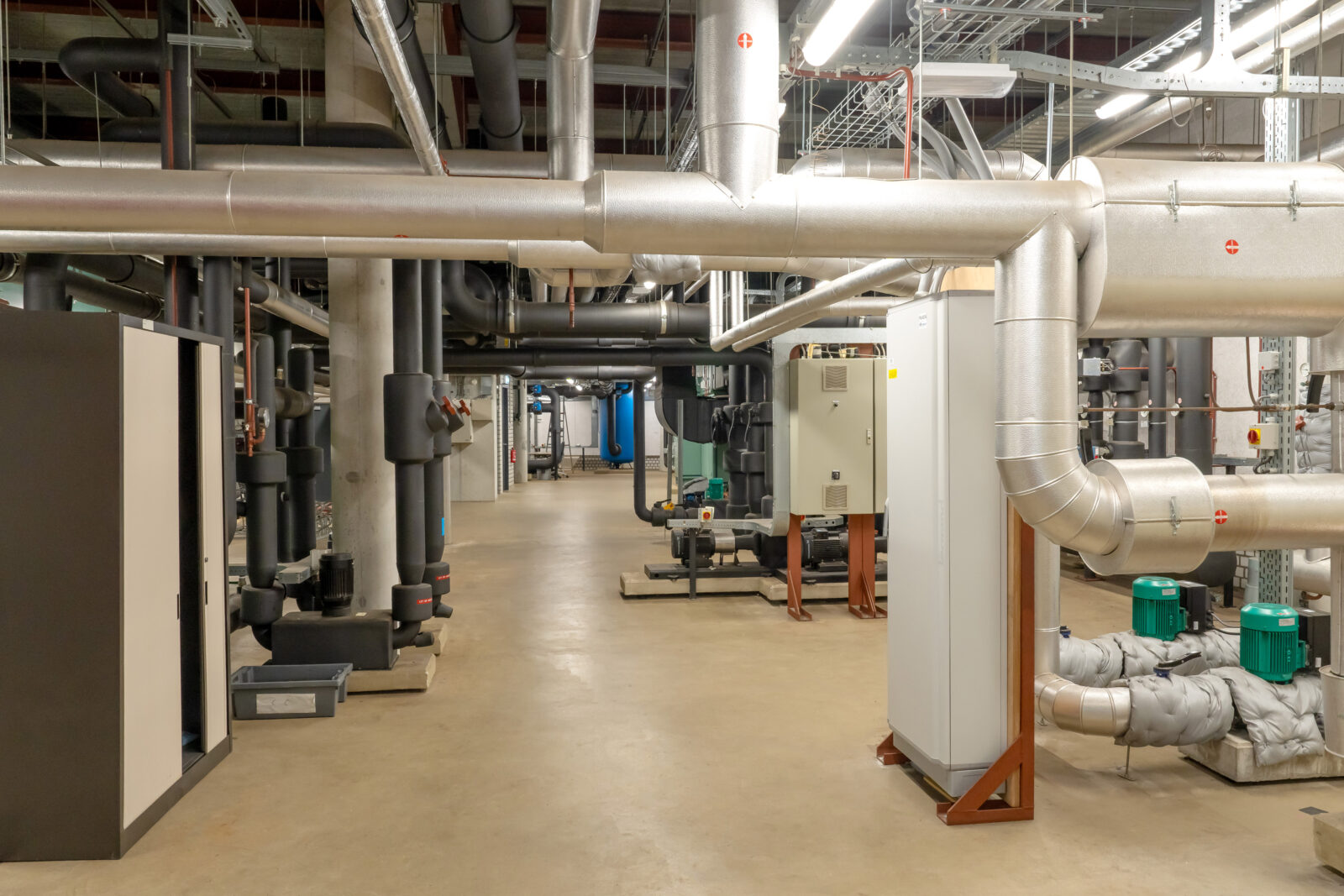 Overzicht technische ruimte met leidingen, pompen en schakelkasten van de installatie