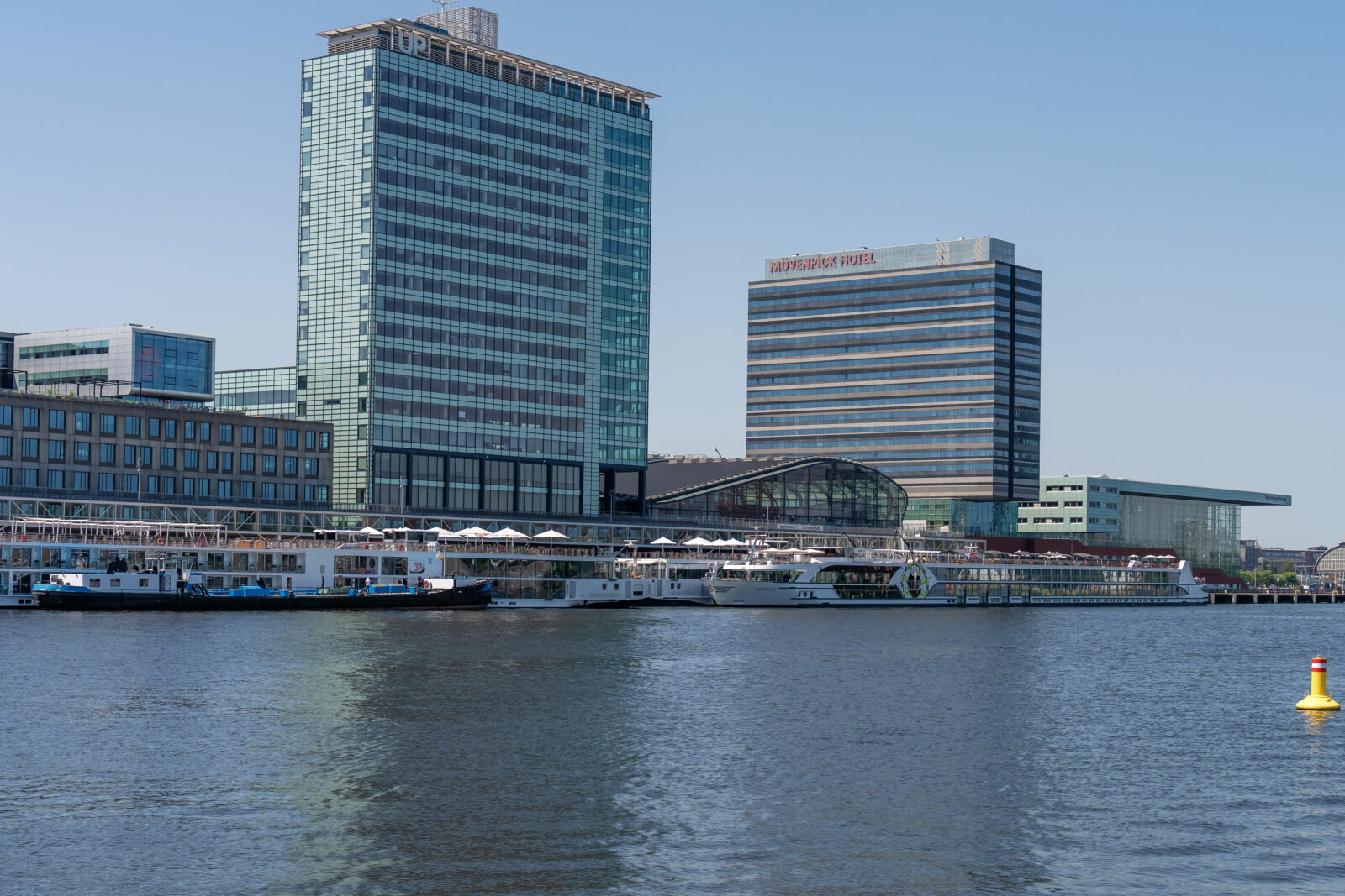 Skyline Amsterdam met Mövenpick Hotel en rivierschepen aan de kade