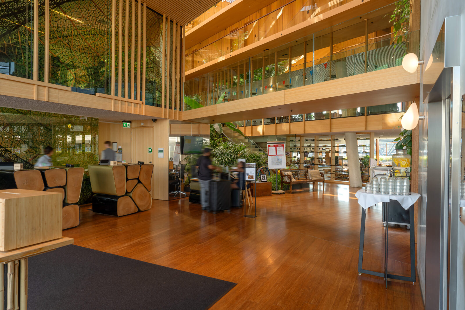 Lobby van Hotel Jakarta met houten vloer, balie en groene begroeiing